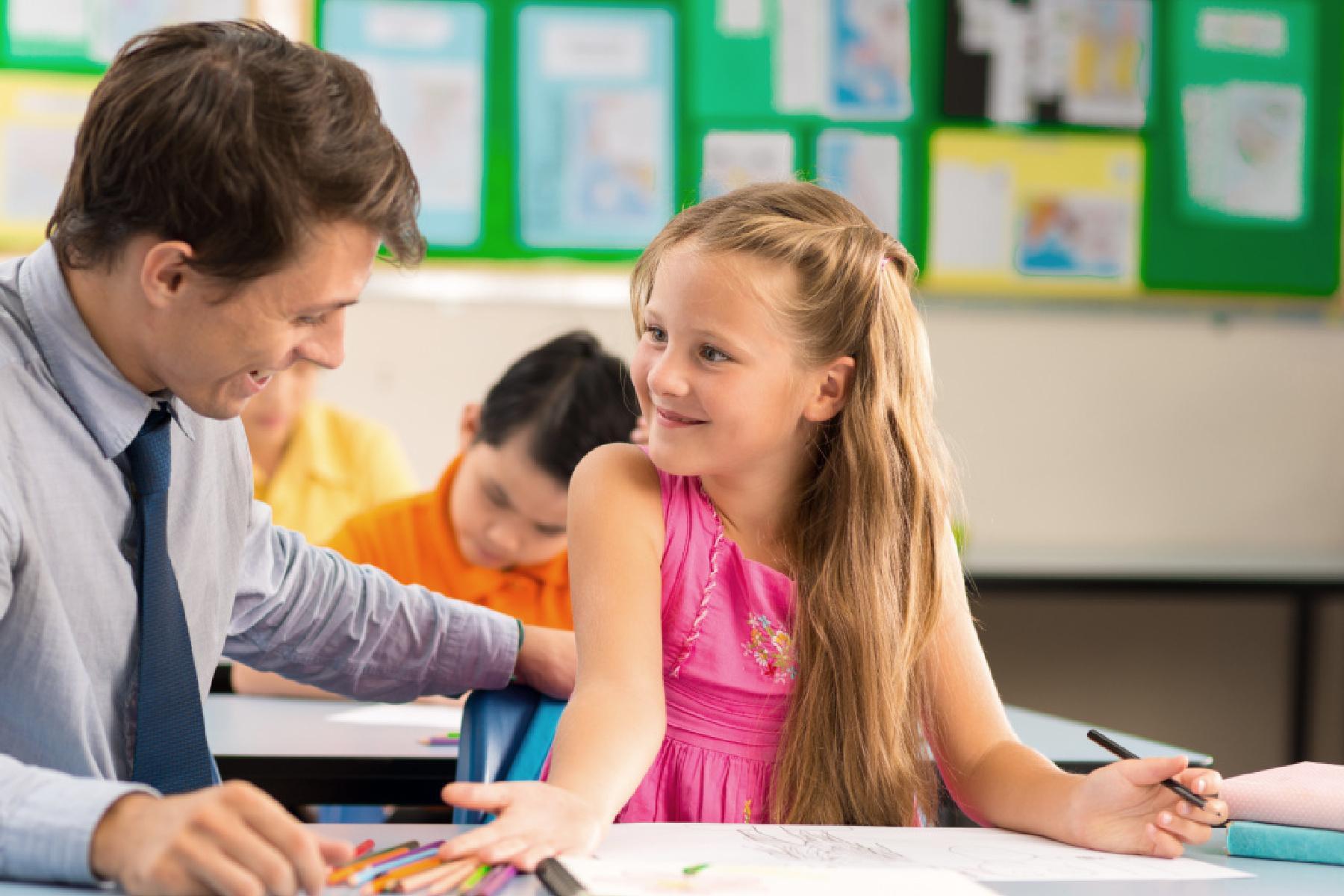 Teacher looking at drawing of his pupil at lesson